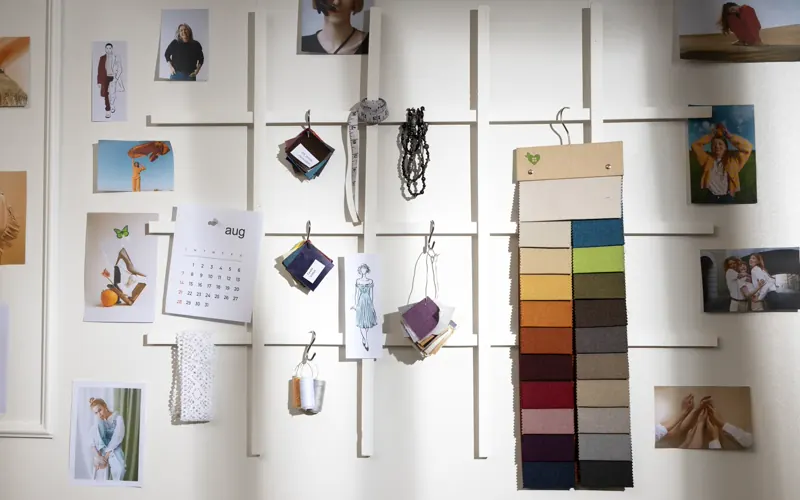 Ściana z moodboardem: zdjęcia, próbki materiałów i palety kolorów w pracowni projektowej